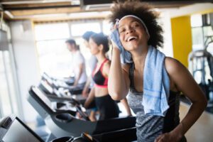 Woman on treadmill wiping forehead